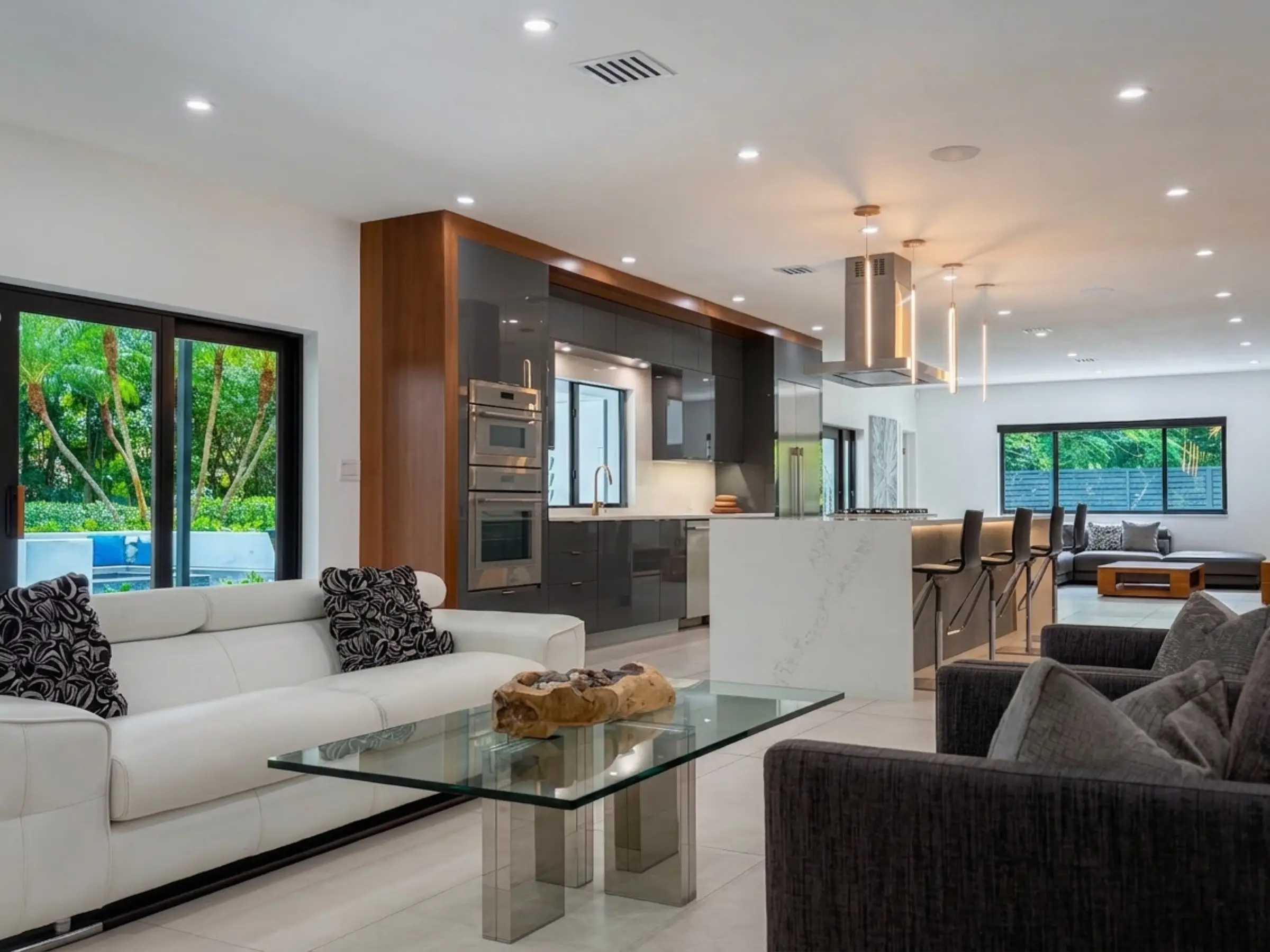 Living room hero — open floor plan with floor-to-ceiling impact glass and large-format porcelain tile