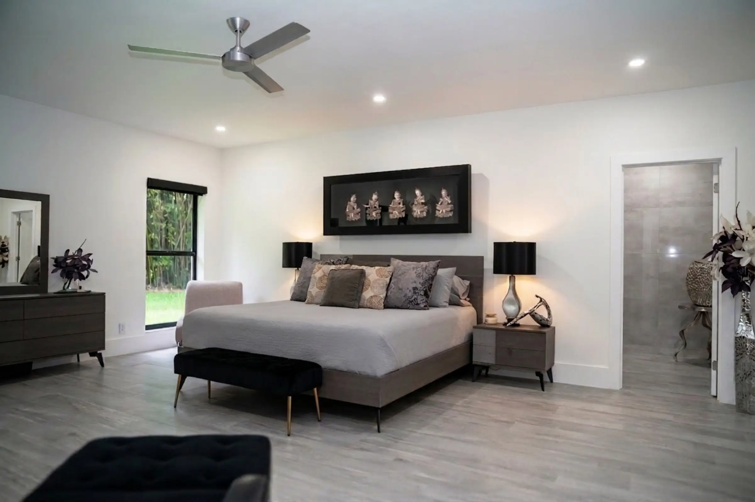 Primary bedroom with morning light and garden view